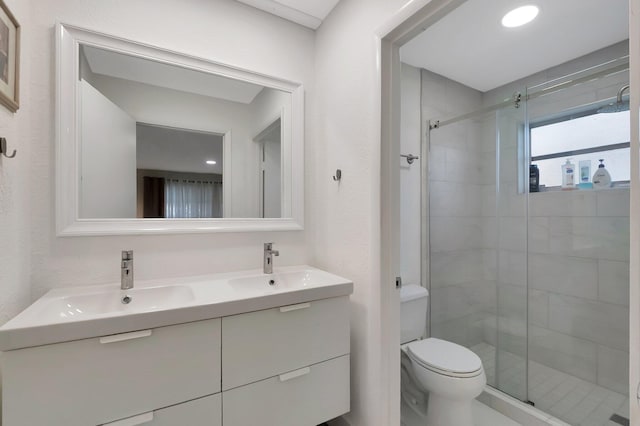 bathroom featuring an enclosed shower, vanity, and toilet