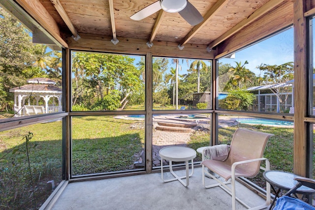 unfurnished sunroom with ceiling fan