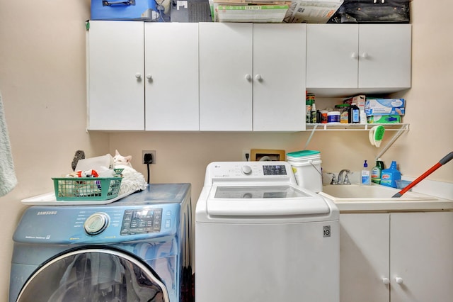 laundry area with sink, independent washer and dryer, and cabinets