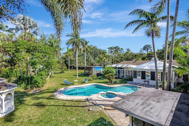 view of pool featuring a lawn, a patio, and an in ground hot tub