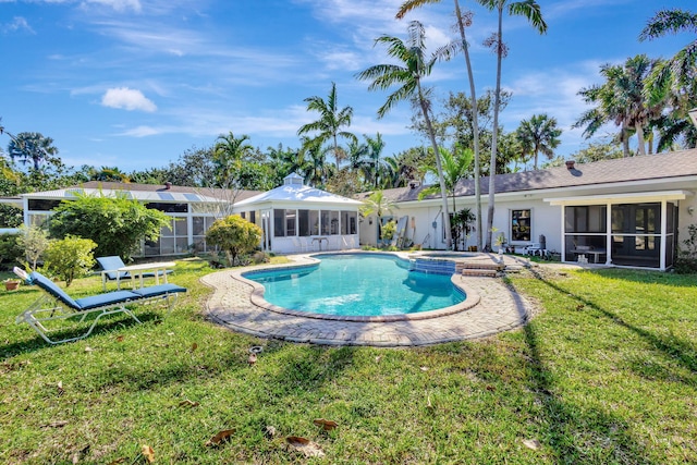 view of pool with a lawn, a sunroom, and an in ground hot tub