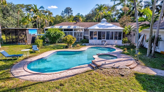 view of swimming pool featuring an in ground hot tub, a lawn, and glass enclosure