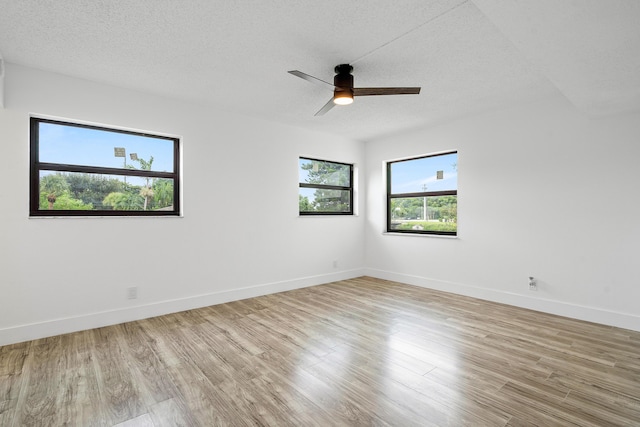 unfurnished room featuring ceiling fan, light wood-type flooring, and a textured ceiling