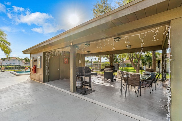 view of patio with a fenced in pool and area for grilling