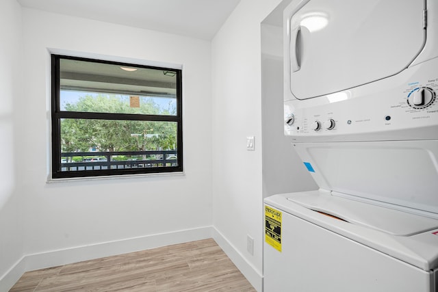 laundry room with stacked washer and dryer and light wood-type flooring