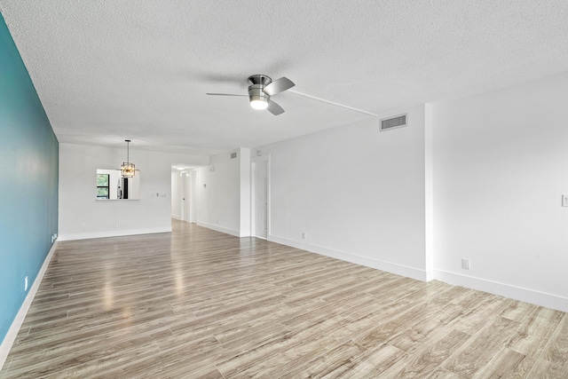 spare room with ceiling fan, light wood-type flooring, and a textured ceiling