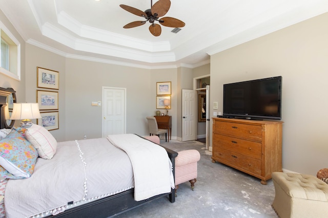 bedroom with ornamental molding, concrete floors, and a tray ceiling