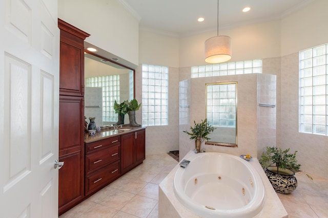 bathroom featuring vanity, tiled tub, tile patterned flooring, and ornamental molding