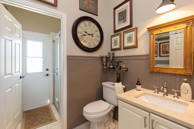 bathroom with walk in shower, tile patterned floors, vanity, and toilet