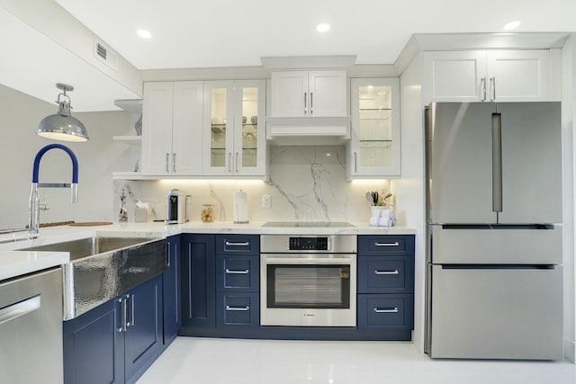 kitchen with stainless steel appliances, white cabinetry, and blue cabinets