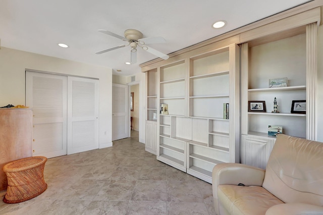 sitting room featuring built in shelves and ceiling fan