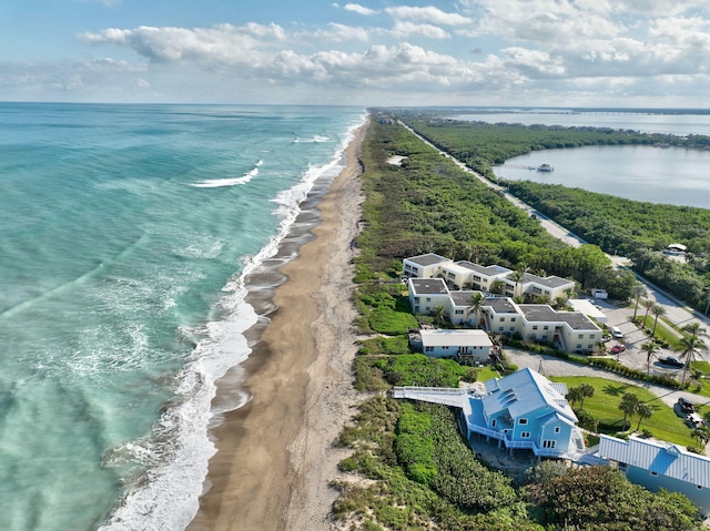 drone / aerial view with a water view and a beach view