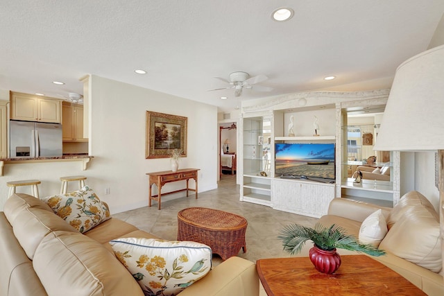 living room featuring ceiling fan, light tile patterned floors, and a textured ceiling