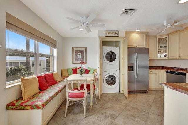 laundry area featuring stacked washing maching and dryer and ceiling fan