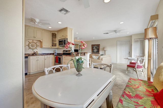 dining space with an AC wall unit, sink, and light tile patterned flooring