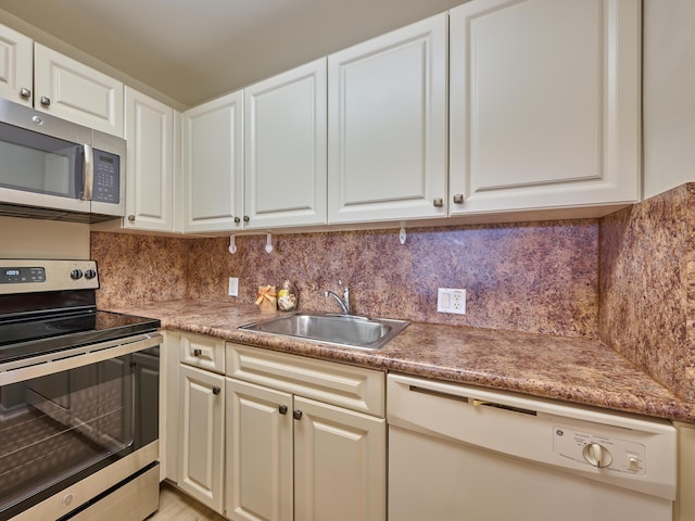 kitchen with backsplash, sink, white cabinets, and stainless steel appliances