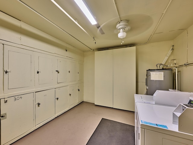 laundry room featuring washing machine and clothes dryer, water heater, ceiling fan, and cabinets