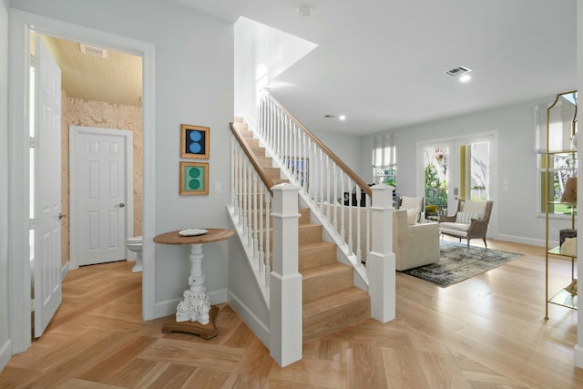 stairway with french doors and parquet flooring