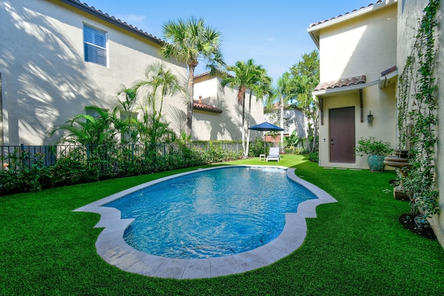 view of pool with a yard