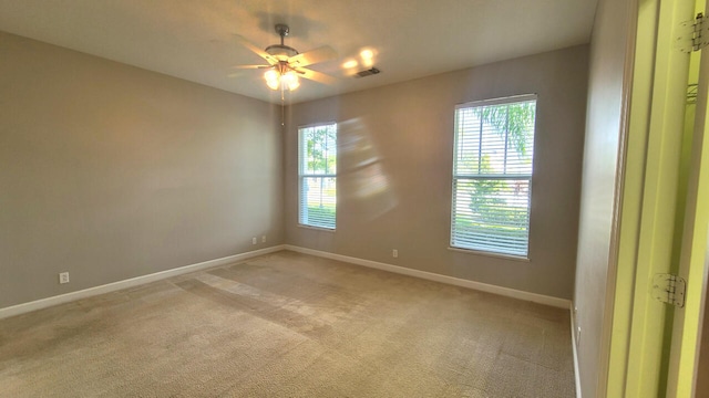 empty room featuring light colored carpet, plenty of natural light, and ceiling fan