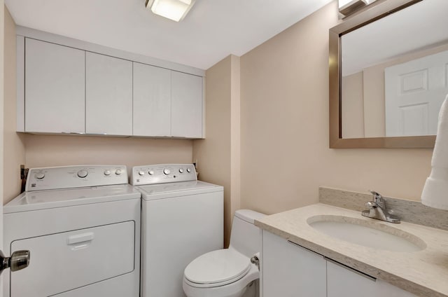 bathroom featuring vanity, toilet, and washing machine and dryer