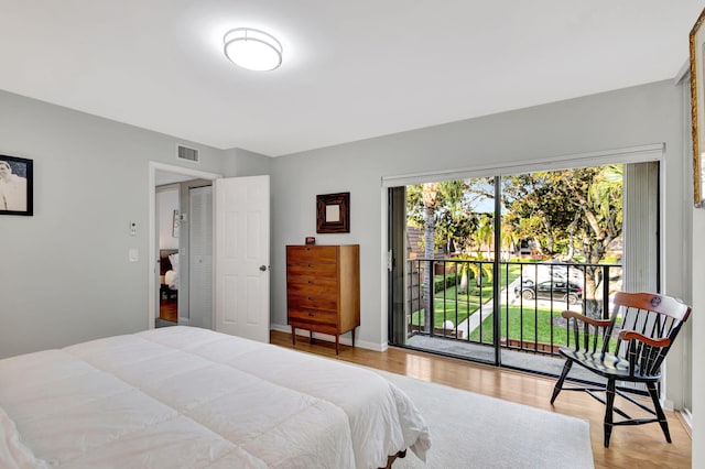 bedroom featuring access to exterior and light hardwood / wood-style flooring