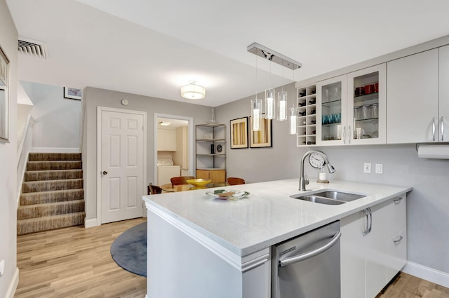 kitchen featuring white cabinets, dishwasher, kitchen peninsula, and sink