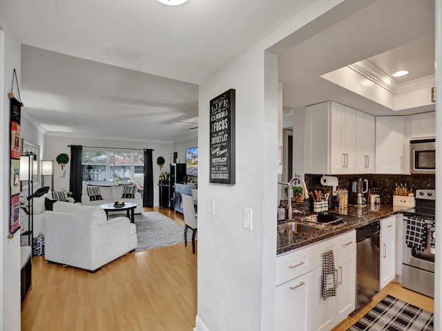 kitchen featuring sink, white cabinets, light wood-type flooring, and appliances with stainless steel finishes