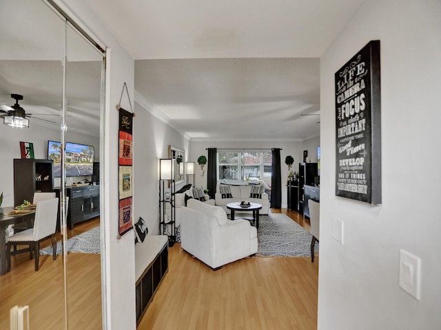 living room featuring wood-type flooring, ceiling fan, and ornamental molding