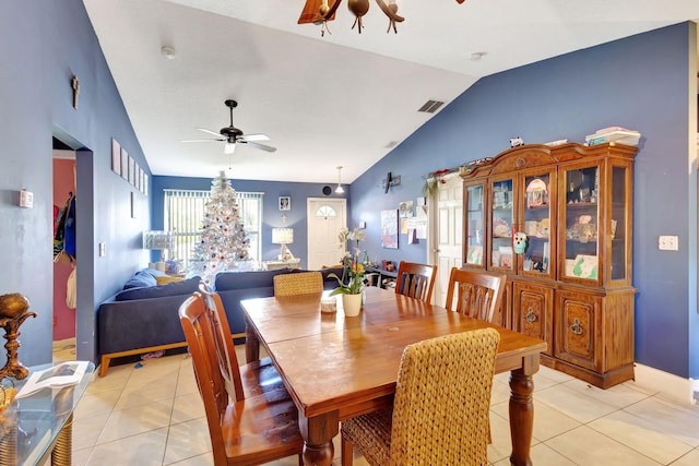 tiled dining space with ceiling fan with notable chandelier and vaulted ceiling