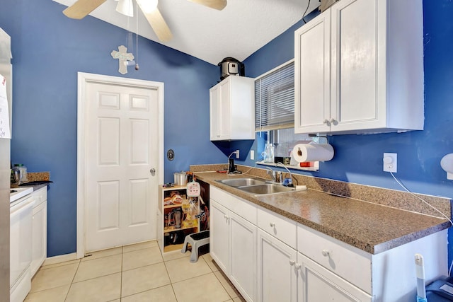 kitchen with white cabinetry, sink, ceiling fan, light tile patterned flooring, and range