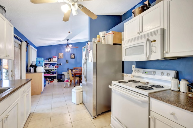 kitchen with white cabinetry, a textured ceiling, lofted ceiling, white appliances, and light tile patterned floors