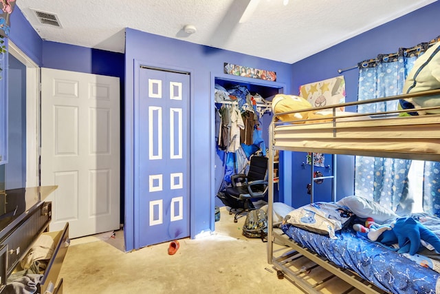 bedroom with a textured ceiling and a closet