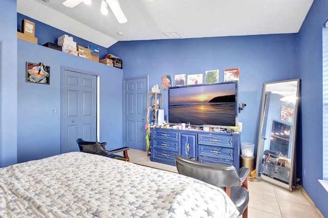 tiled bedroom with a closet, vaulted ceiling, and ceiling fan