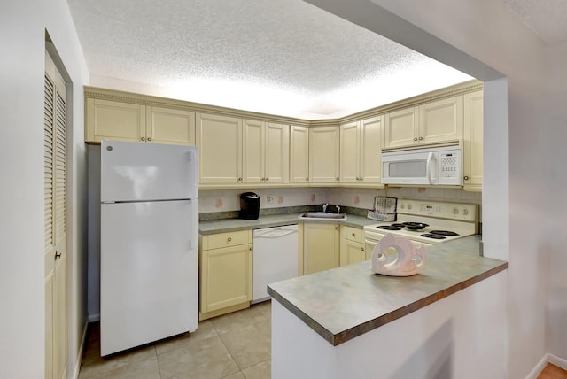 kitchen featuring sink, kitchen peninsula, cream cabinets, white appliances, and light tile patterned floors