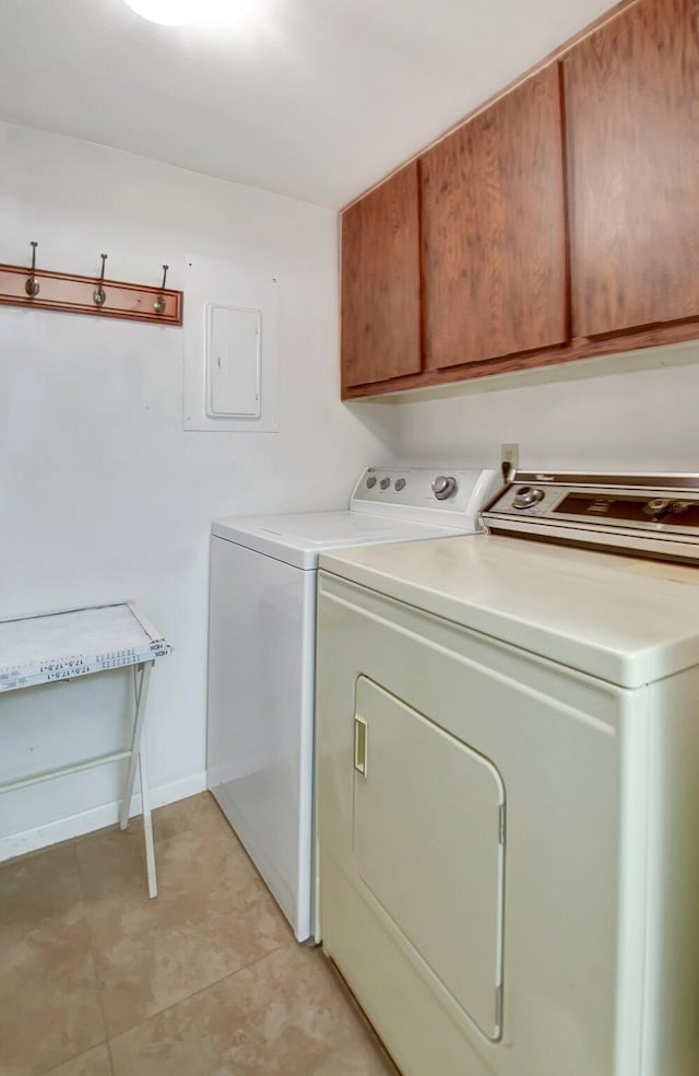 clothes washing area featuring washer and clothes dryer and cabinets