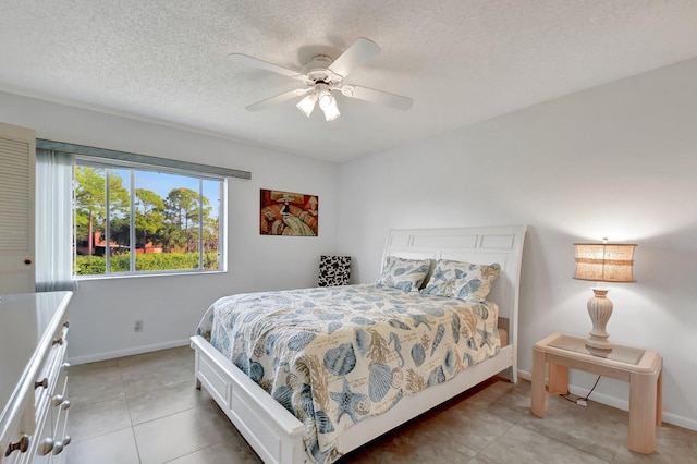 bedroom with ceiling fan and a textured ceiling