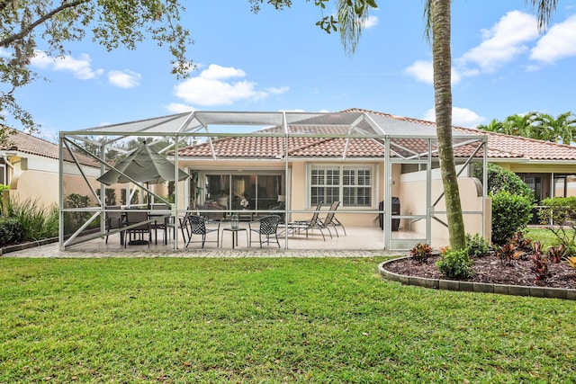 rear view of property featuring a yard, a patio, and a lanai