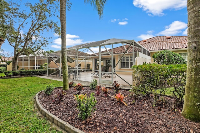 rear view of property featuring a lawn, glass enclosure, and a patio area