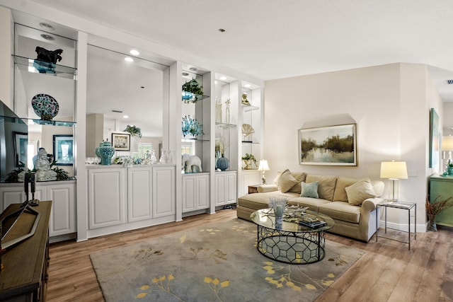 living room with light wood-type flooring and built in features