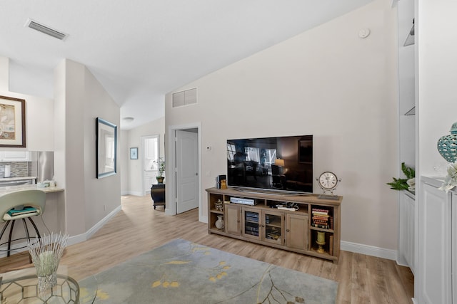 living room featuring light wood-type flooring and lofted ceiling