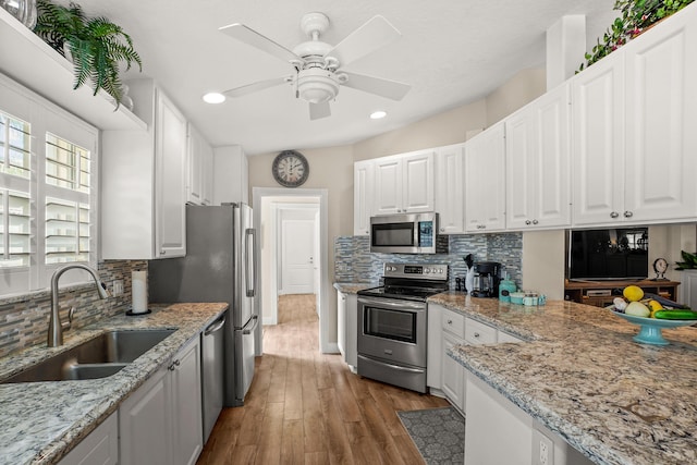 kitchen featuring decorative backsplash, white cabinetry, sink, and stainless steel appliances