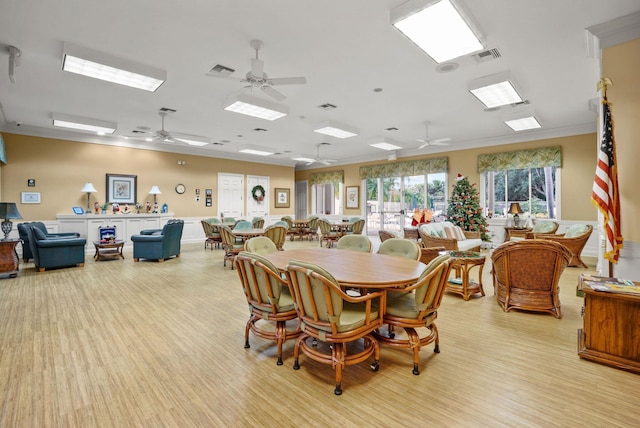 dining space featuring light hardwood / wood-style flooring, ceiling fan, and ornamental molding