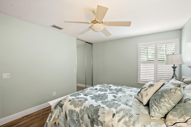 bedroom with dark hardwood / wood-style floors, a closet, and ceiling fan