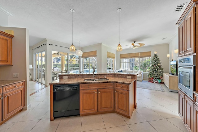 kitchen featuring black dishwasher, brown cabinets, visible vents, stainless steel oven, and a sink