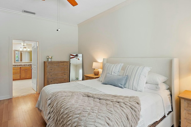 bedroom with visible vents, a ceiling fan, light wood-style flooring, ensuite bathroom, and crown molding