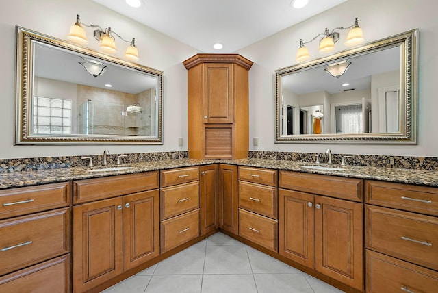 bathroom featuring a tile shower, tile patterned flooring, and vanity