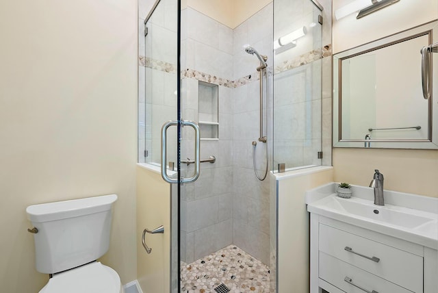 bathroom with toilet, a stall shower, and vanity