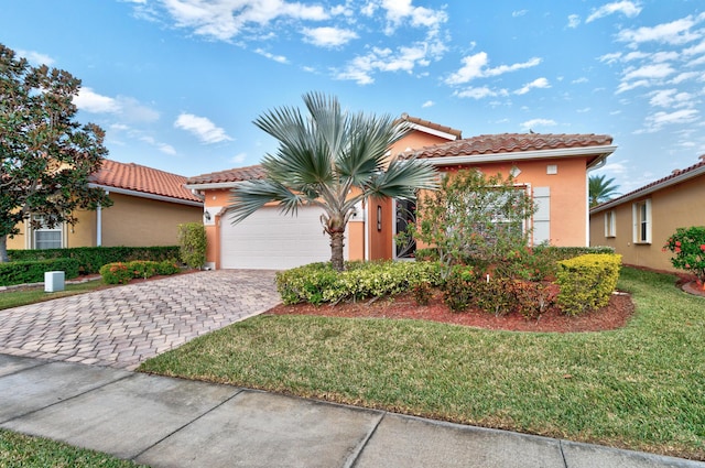 mediterranean / spanish-style home with a garage and a front lawn