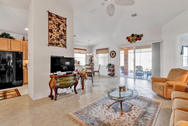 living room featuring light tile patterned floors, ceiling fan with notable chandelier, and lofted ceiling